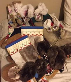 Image of many different pairs of kamiks and slippers by the author Tanya Elias. 