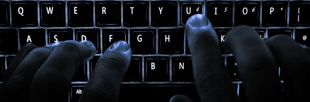 Fingers typing at a keyboard in the dark