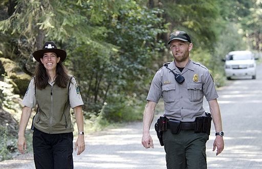 Two park rangers walking down a street