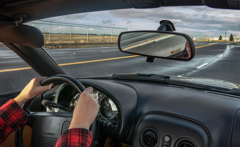 Image depicting passenger view of person driving a car.