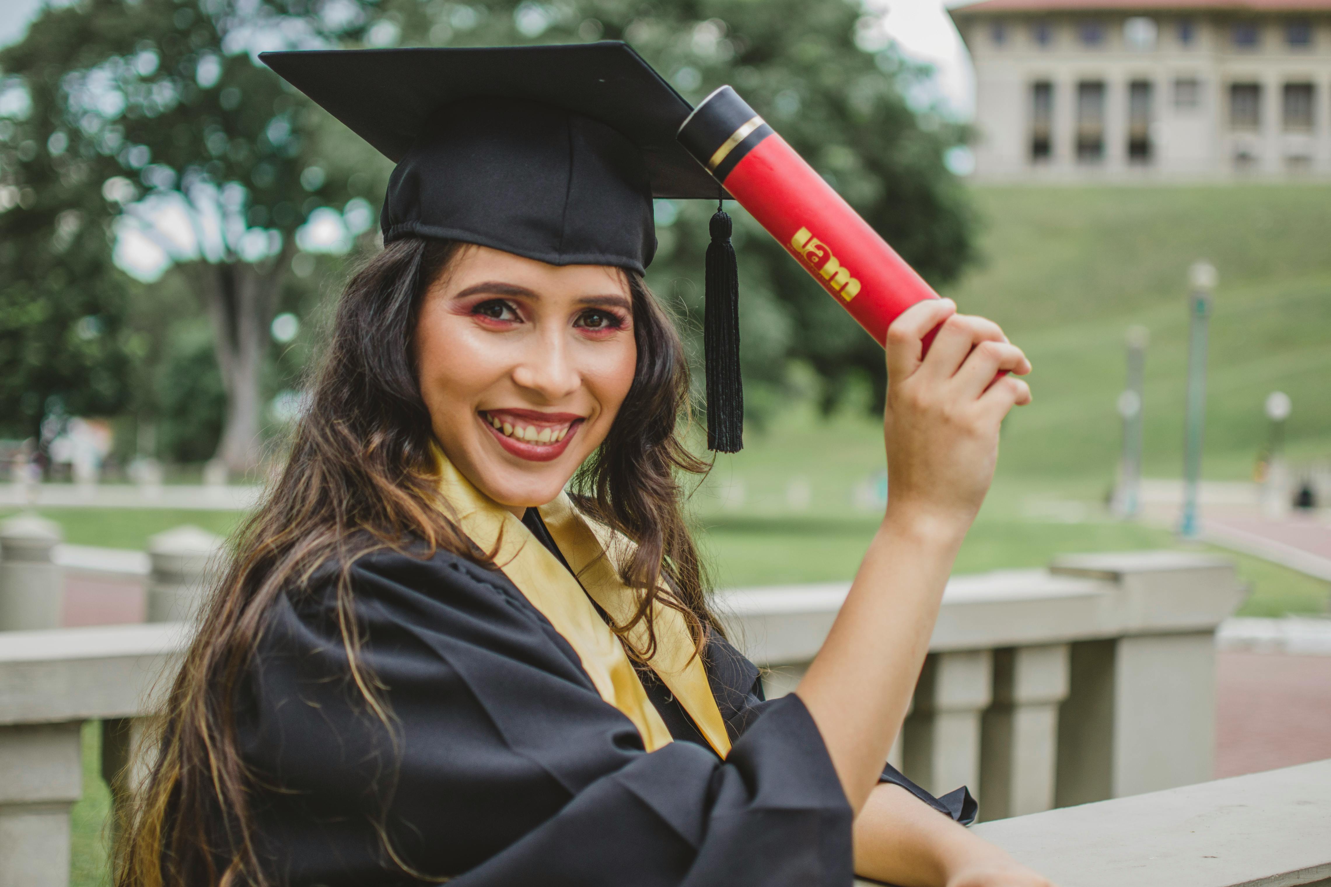 A woman holding her diploma on her graduation day